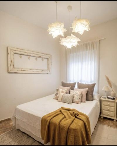 a bedroom with a large bed with two chandeliers at MARBELLA - MIJAS in Mijas