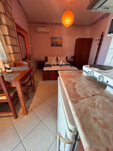 a kitchen and living room with a table and a bed at Simos Apartments in Korinos