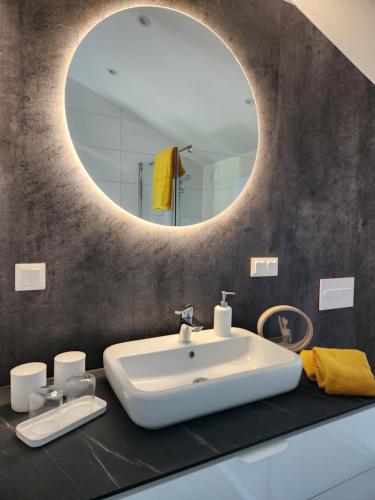 a bathroom with a white sink and a mirror at Bei Herze - Tiny Wohnen im Odenwald in Bad König