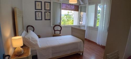 a bedroom with a white bed and a window at La Collina dei Conigli - immersi nella natura in Castellarano