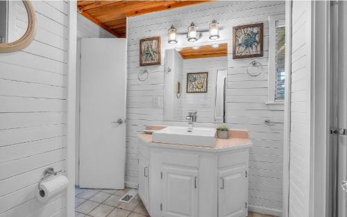 a white bathroom with a sink and a shower at Isle be sea'n you in Rodanthe