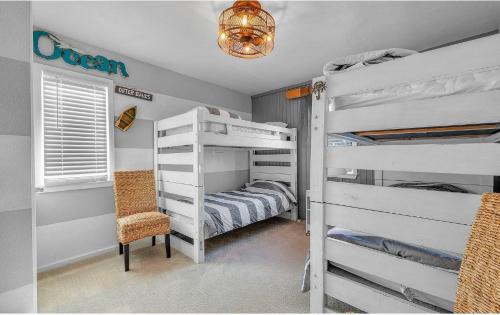 a bedroom with two bunk beds and a chair at Isle be sea'n you in Rodanthe