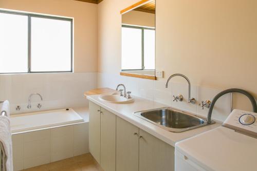a bathroom with a sink and a bathtub and a sink at Wyadup Brook Cottages in Yallingup