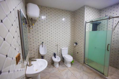 a bathroom with two toilets and a sink and a shower at Diplomats Enclave Suites in Jikoyi