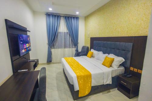 a hotel room with a bed and a television at Diplomats Enclave Suites in Jikoyi