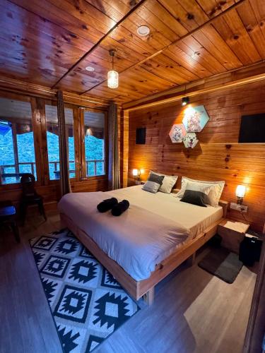 ein Schlafzimmer mit einem großen Bett in einem Holzzimmer in der Unterkunft Zoella in Gushaini