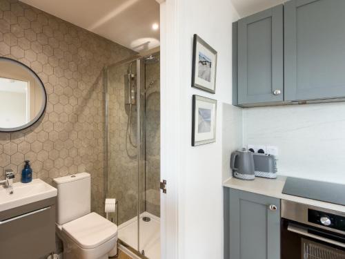 a bathroom with a shower and a toilet and a sink at Bothan By The Bay, Benbecula in Grimsay