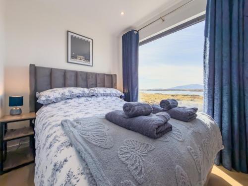 a bedroom with a bed with towels on it at Bothan By The Bay, Benbecula in Grimsay