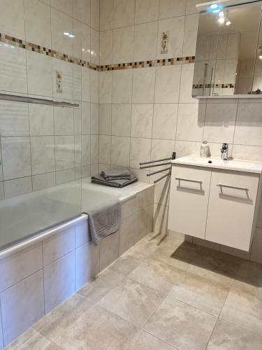 a bathroom with a tub and a sink at Design-Apartment am Wildbach mit Bergblick & direktem Zugang zur Natur in Fischbachau
