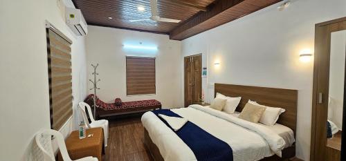 a bedroom with a bed and a bench in a room at Johny's Villa, Homestay, Wayanad in Pulpally