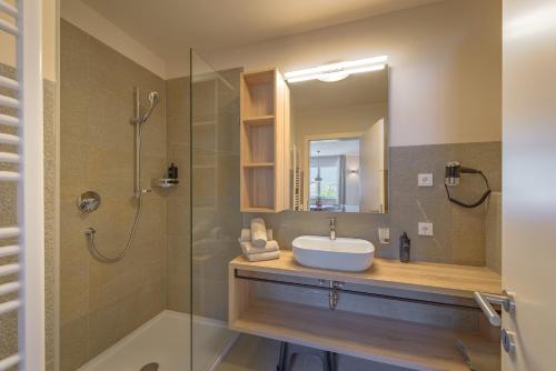 ein Badezimmer mit Waschbecken und Glasdusche in der Unterkunft Hotel Cornelian Suites & Rooms in Appiano sulla Strada del Vino