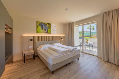 ein Schlafzimmer mit Bett und Balkon in der Unterkunft Hotel Cornelian Suites & Rooms in Appiano sulla Strada del Vino