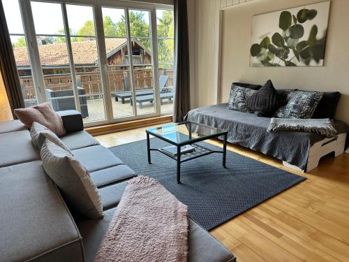a living room with a couch and a coffee table at Design-Apartment am Wildbach mit Bergblick & direktem Zugang zur Natur in Fischbachau