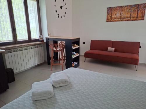 a bedroom with a bed and a red couch at The One Malpensa Rooms in Vizzola Ticino