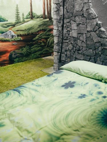a bed in front of a wall with a painting at URBAN PIC NIC in Piazza Brembana