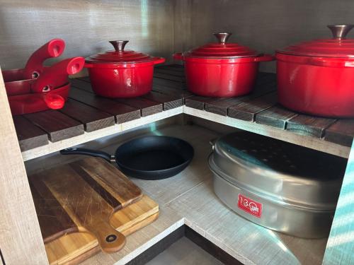 a kitchen with red pots and pans on a shelf at 127 Clarens Golf Villa in Clarens