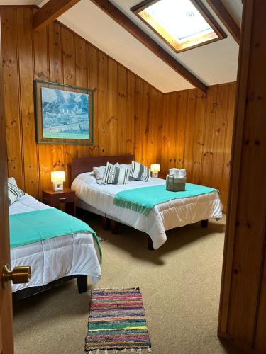 a bedroom with two beds and a skylight at Casa Amparo in Frutillar