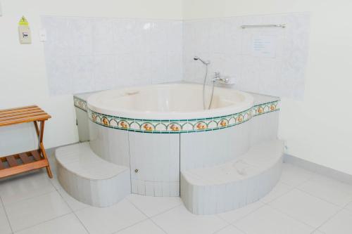 a white bathroom with a tub and a sink at Zentra San José Hotel & Cowork in Chiclayo