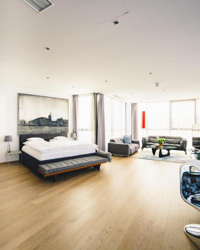 a bedroom with a bed and a living room at Augarten Art Hotel, a Member of Design Hotels in Graz