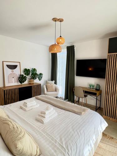 a bedroom with a large white bed and a desk at Casa Katarina in Novalja