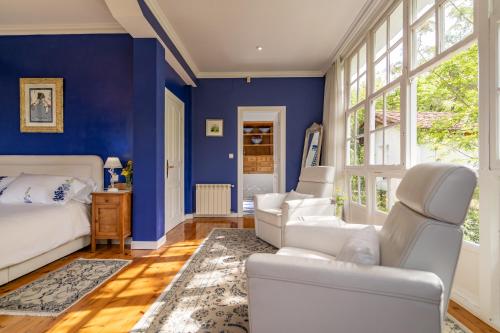 a bedroom with blue walls and white furniture at Villa Elena in Potes