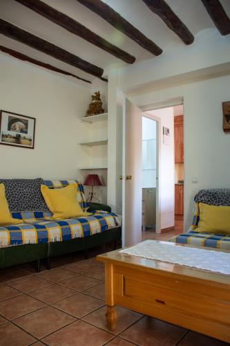 a living room with two beds and a table at Apartamentos Casa Ferrás in Valderrobres
