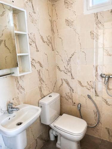 a bathroom with a toilet and a sink at Modern and Calm Apartment in Mahdia near Beach in Rejiche