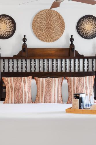 a bedroom with a bed with pillows and lights at Hotel Boutique Patio Corao by GEH Suites in Cartagena de Indias