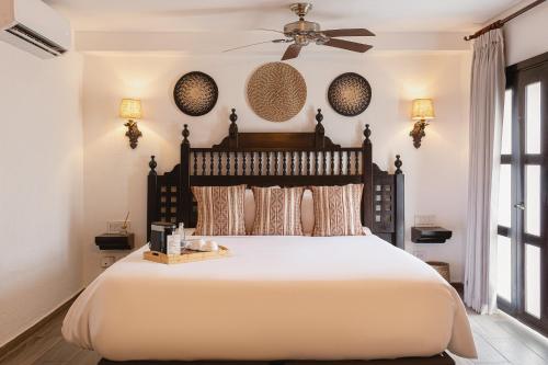 a bedroom with a large bed and a ceiling fan at Hotel Boutique Patio Corao by GEH Suites in Cartagena de Indias