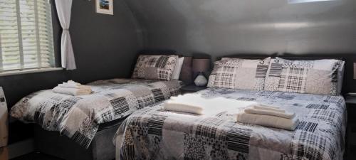 a bedroom with two beds with towels on them at Clifden Glen House in Clifden