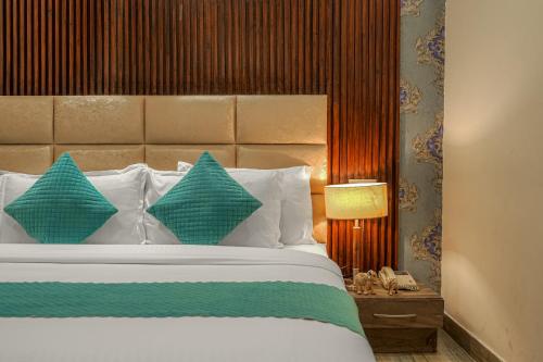 a bedroom with a bed with blue and white pillows at Hotel Heritage Street ! 100m from Golden Temple ! Parking & Restaurant in Amritsar