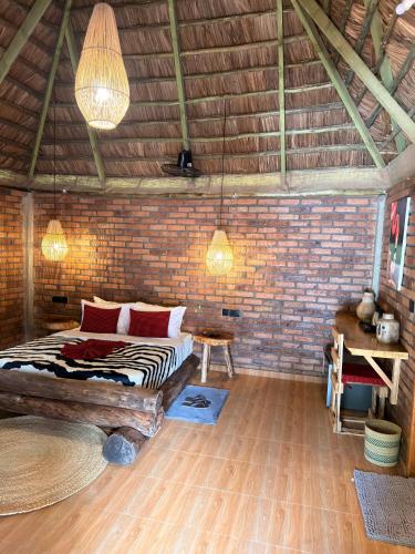 a bedroom with a bed and a brick wall at Villa Rosa in Moshi
