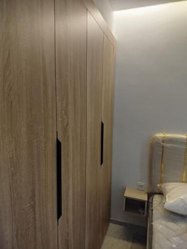 a bedroom with a wooden cabinet next to a bed at Riad Andalous in Ariana