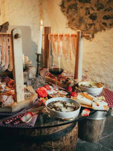 a table with food and a glass of wine and candles at Il Roccolino in Valsecca