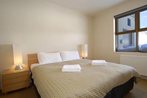a bedroom with a large bed with two towels on it at Chalet Hotham 1 in Mount Hotham