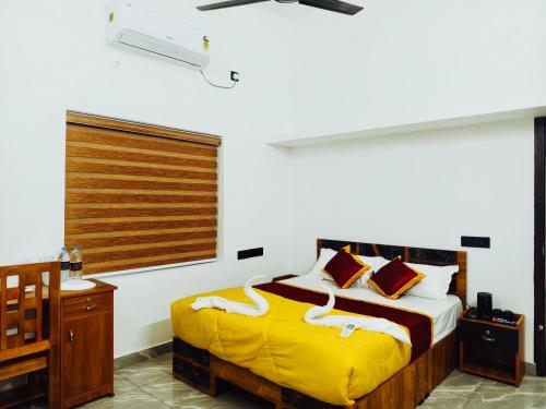 a bedroom with a bed with a yellow blanket at Nilavu villas in Alleppey