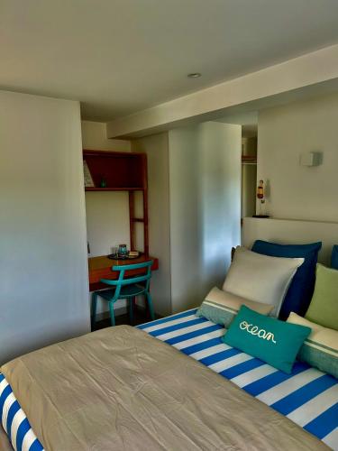 a bedroom with a bed with a blue and white blanket at Etoile du Kap in Barneville-Carteret