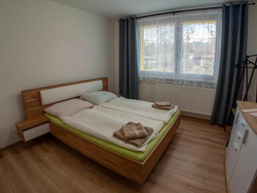 a small bedroom with a bed with a window at Apartmán Gerlach in Vyšné Hágy