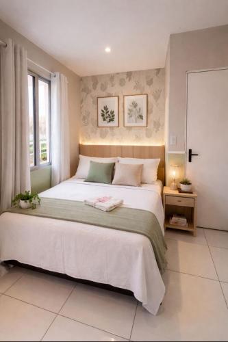 a bedroom with a large bed and a window at Pousada Meu Aconchego in Fortaleza