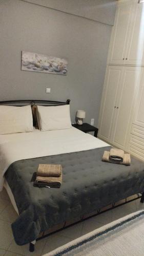 a bedroom with a large bed with two towels on it at Earth n' Water in Verga Kalamata