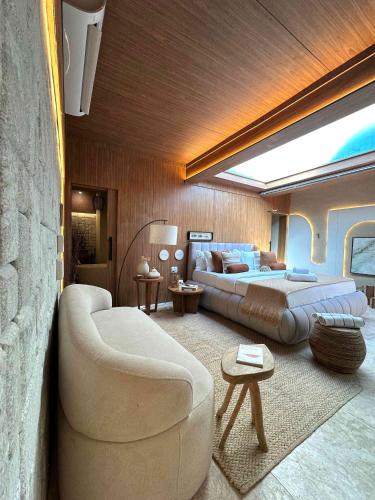 a living room with a couch and a bed at SDesign Paraty Hotel in Paraty