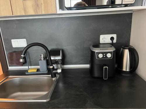 a kitchen counter with a sink and a coffee maker at KiShouse in Burgas