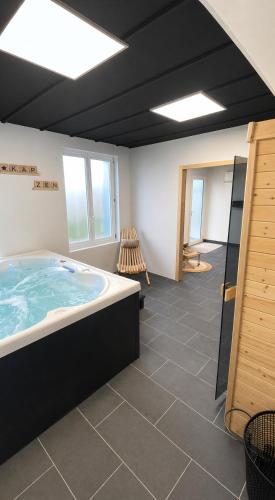 a large bathroom with a hot tub in a room at Etoile du Kap in Barneville-Carteret