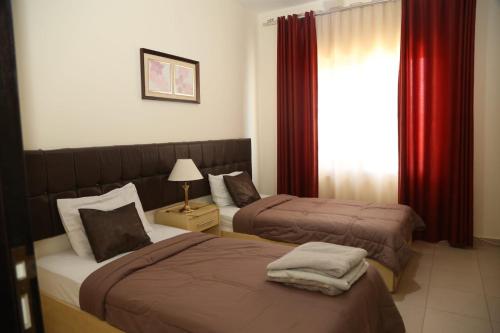 a hotel room with two beds and a window at Apartment Samarah Resort D44 at DeadSea, Sea & Pool view-Families & couples only in Sowayma