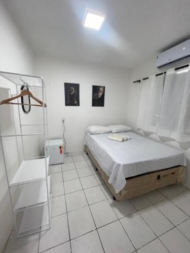 a bedroom with a bed in a white room at Hospedagem Sousa in Santa Inês