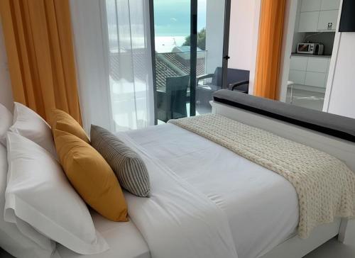 a white couch with pillows and a window in a room at VILLA HELENA Amber Apartment in Caniço