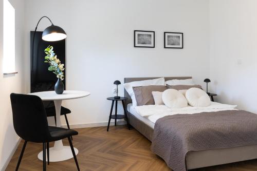 a bedroom with a bed and a table and a chair at Starowiejska Residence 1860 A in Miejsce Piastowe