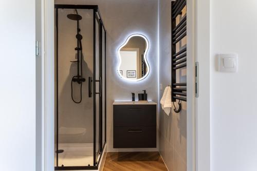 a bathroom with a sink and a shower with a mirror at Starowiejska Residence 1860 A in Miejsce Piastowe