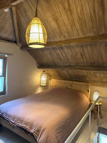 a bedroom with a bed with two lights on it at L'Alterre Durbuy in Durbuy
