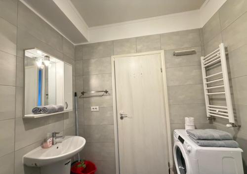 a bathroom with a sink and a washing machine at RC RelaxApart 820 in Dudu
